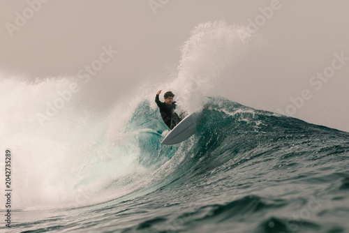 An elite surfer performing a re-entry on a wave