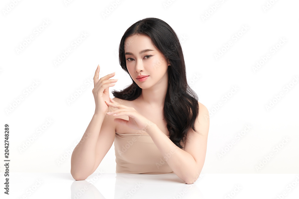 Fototapeta premium A beautiful young Asian woman with clean, fresh skin against a white background. Skincare, facial treatment, cosmetology, beauty, and spa. An elegant portrait of an Asian woman.