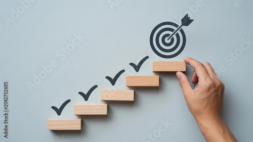 Hand building checklist staircase to hit target goal success strategy concept