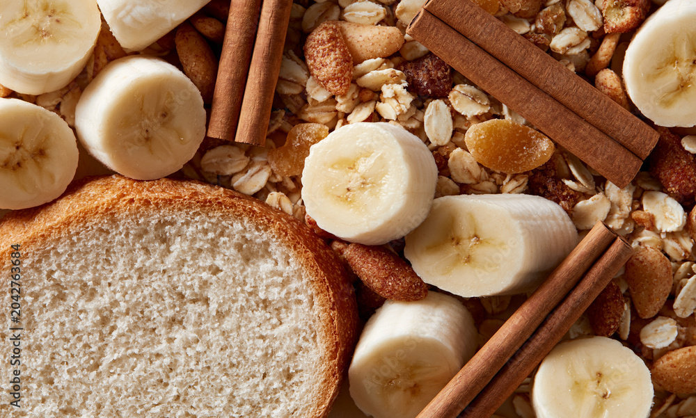 Fototapeta premium Top down very flat lay, entire background fully packed edge-to-edge with two chai sticks, banana pieces, slice of bread. No bowls, plates, containers