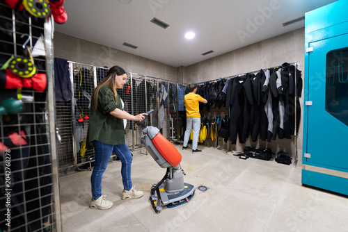 Dive center staff using floor scrubber for cleaning