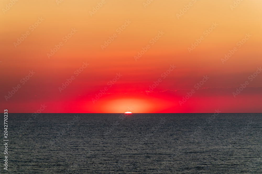 Fototapeta premium Beautiful red and orange sunrise over the sea.