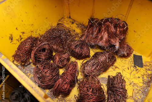 Photography Raw copper wire scrap waiting to recycle in yellow bin creates messy but highly