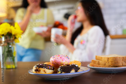 Assorted donuts and toast on plates, unhealthy breakfast or snack. Concept of junk food, obesity risk, and poor eating habits.