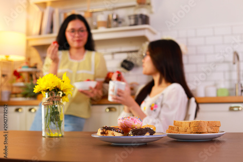 Assorted donuts and toast on plates, unhealthy breakfast or snack. Concept of junk food, obesity risk, and poor eating habits.