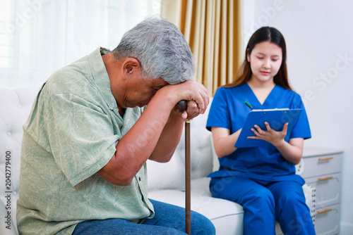 A sick senior man feeling unwell and exhausted while a medical nurse records his vital signs. Diagnosis of chronic illness in the elderly and home treatment services.