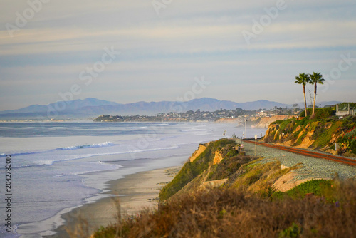 Canvastavla Coastal railroad along the Del Mar bluffs with palms and distant mountains