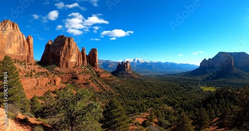 Scenic panoramic view of majestic rock formations and lush greenery under a clear blue sky