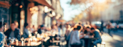 Blurred outdoor cafe scene with people dining on a city street  