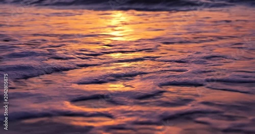 Serene sunset over gentle ocean waves, creating a tranquil atmosphere by the shore
