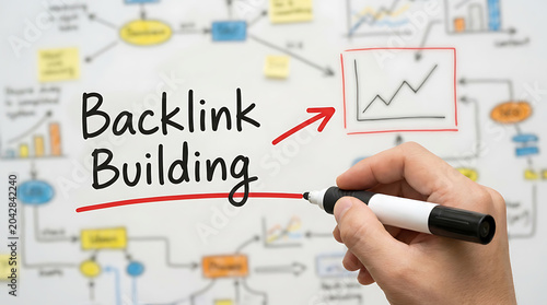 Closeup of a hand writing backlink building on a whiteboard with a marker