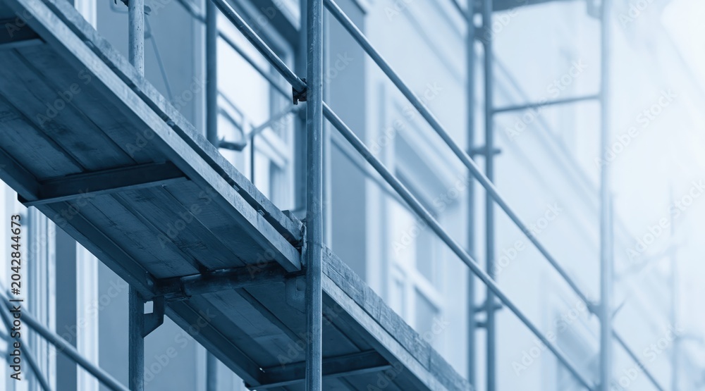 Obraz premium Close up scaffolding with wooden planks and metal rails on building facade