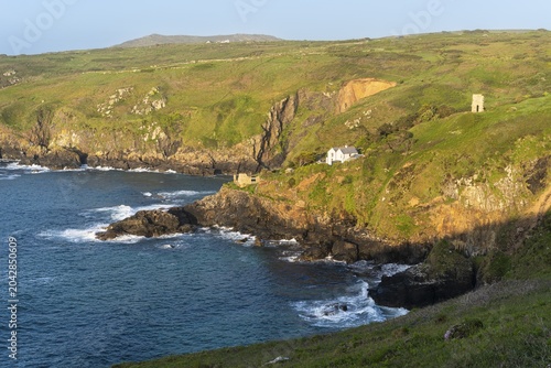 Landscape. On the headland of Gurnard's Head, view along the coast to Treen Cove with a house and Rose-an Hale Cove. The ruins of an old mine on the right. Good weather, blue sky. Gurnard's Head, Cornwall, England, Great Britain