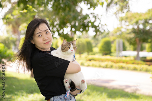 asian woman hug her scottish tabby cat during relax at park