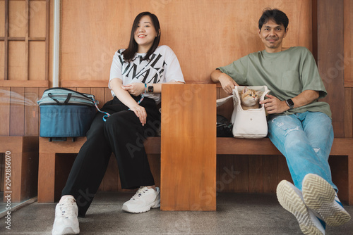 asian couple smile and happy during play with they cat in coffee shop