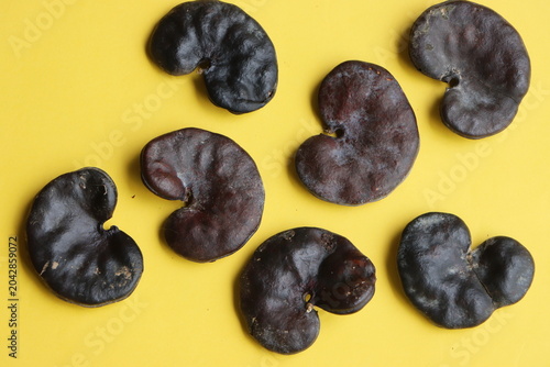 Obraz na płótnie A collection of hard, dark brown Enterolobium contortisiliquum (Earpod tree) seeds, famously known for their distinct ear-like or kidney-shaped appearance