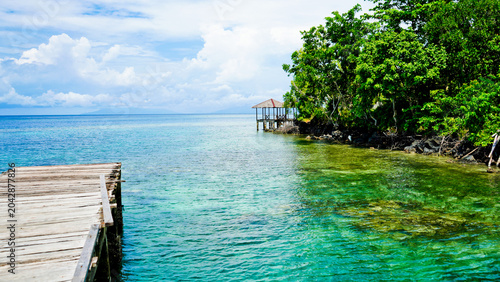 beautiful view of tropical beach with mountain backdrop and clear sky