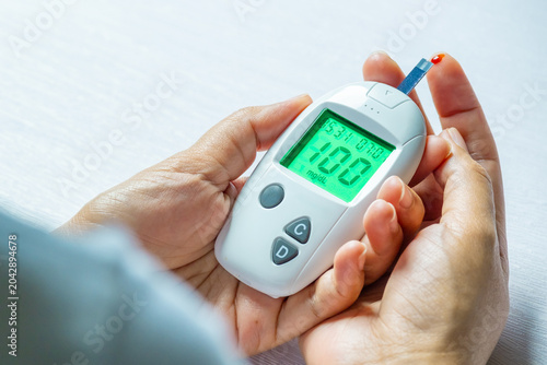 Bild auf Leinwand Woman's hands checking diabetes and hyperglycemia with digital blood sugar meter