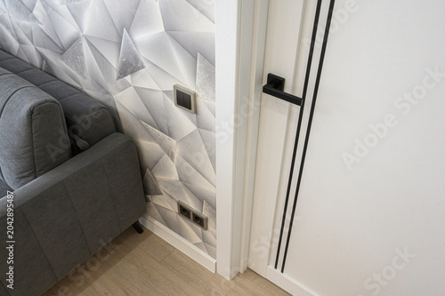 Принти на полотні modern interior corner with a gray upholstered sofa, a white 3D geometric wall p