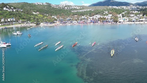 Aerial View of Professional Rowing Teams Competing in a Regatta near Scenic Coastal Town with Mountains. High quality 4k footage