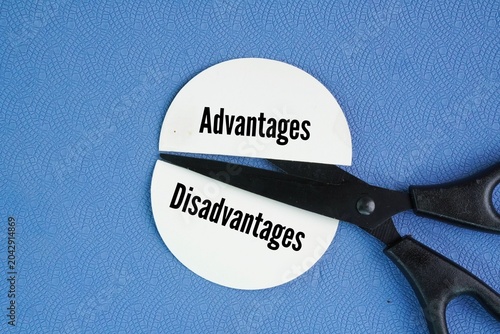 Scissors and two pieces of paper are separated by different words Disadvantage and Advantages. the positive and negative aspects of a choice, situation, or tool. Advantages provide a benefit, gain