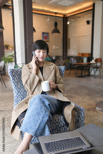 Photography Woman relaxes, sipping coffee, talking on phone