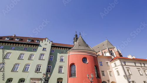 Colorful buildings stand in a row under a clear blue sky in a historical part of the city during daytime in Poland. Small Market Square in Krakow