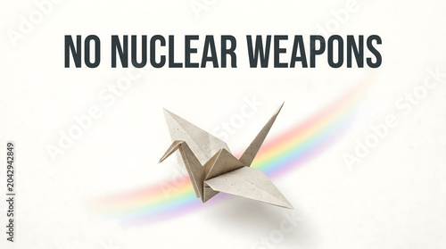 A banner reading “No to Nuclear Weapons” featuring an origami paper crane and a rainbow, representing the concept of the International Day Against Nuclear Weapons.  AI generated.