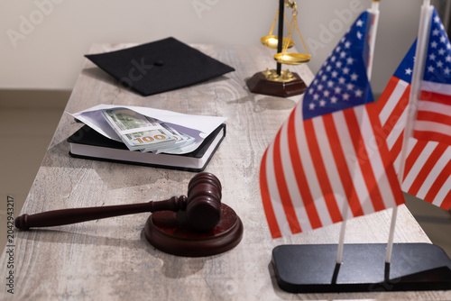 Wooden judge gavel close up on desk table surface with office documents