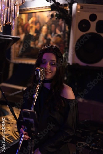 Photography Female singer performing at vintage microphone in jazz club, Paris