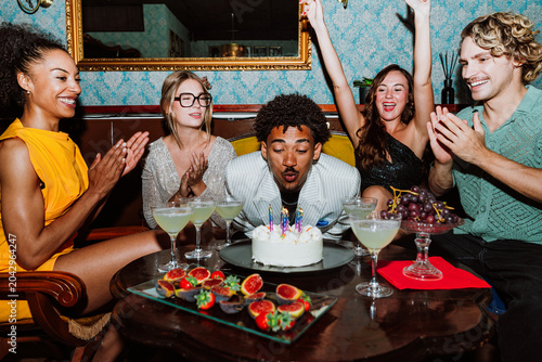 Diverse friends celebrating birthday party with cake and cocktails