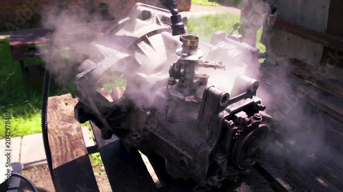 cleaning and washing with a steam cleaner of an old manual transmission from a front-wheel drive car for repair