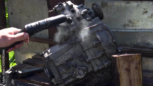 cleaning and washing with a steam cleaner of an old manual transmission from a front-wheel drive car for repair