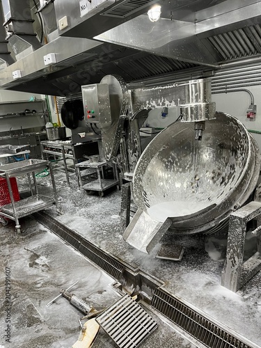 Food processing equipment being cleaned with foaming detergent after production. Industrial sanitation procedure supporting food safety, hygiene control, and contamination prevention in a food manufac