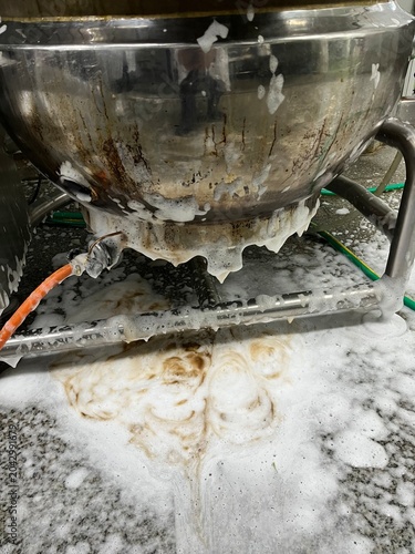 Food processing equipment being cleaned with foaming detergent after production. Industrial sanitation procedure supporting food safety, hygiene control, and contamination prevention in a food manufac