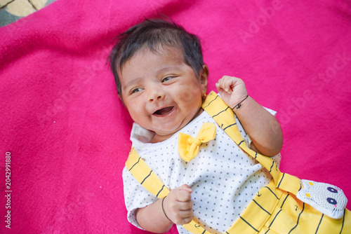 Foto cute indian baby girl laying on pink soft cloth