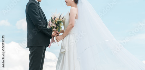 Fotografie Bride and groom against a sky backdrop (wedding, marriage ceremony, bridal, loca