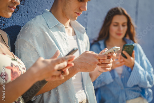 Tableau sur toile Young people using smart phones ignoring each other outdoors