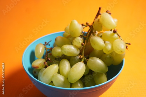 Fresh green grapes hanging in clusters, juicy, nutritious, naturally sweet, and refreshing fruit.