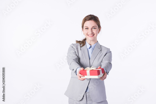 Smiling businesswoman offering a wrapped gift box on white background