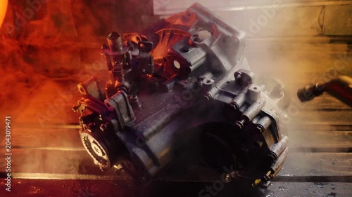 cleaning and washing with a steam cleaner of an old manual transmission from a front-wheel drive car for repair evening video shooting with red and purple lighting