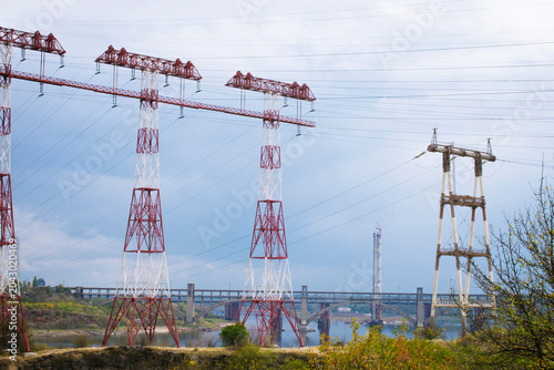 Принти на полотні High voltage electricity transmission masts and power lines silhouette against the backdrop of  bridge