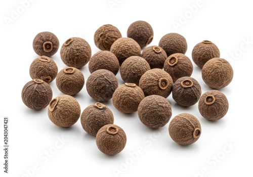 Group of whole allspice berries scattered on a clean solid white background