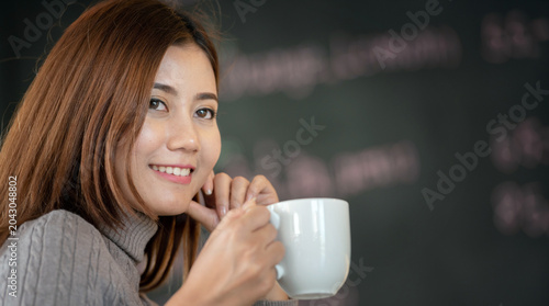 Foto Banner of Asian woman Proprietor holding hot coffee in white ceramic cup to sniff smell of espresso in office work place