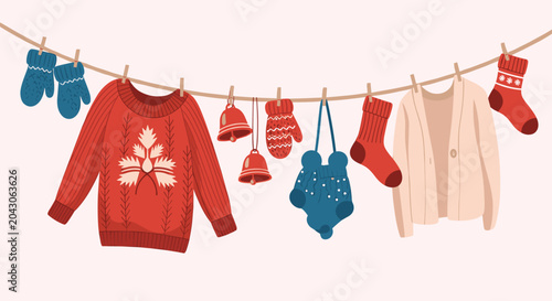 Assorted winter clothes including a red sweater with leaf pattern hat mittens and socks hanging on a clothesline for festive laundry concept.