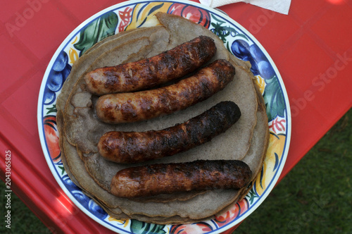 Saucisses de Toulouse grillées sur des galettes bretonnes dans une assiette vues de dessus
