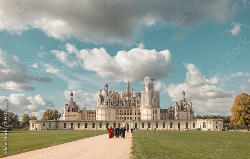Cuadro en lienzo A group of people walk along a path leading to the stunning Chateau de Chambord