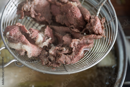 Obraz na plátně Colander holding blanched Chaoshan fresh beef