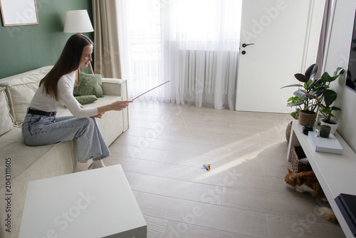 Happy woman with cat playing and having fun at home