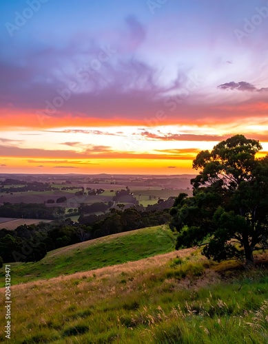 A serene landscape photo of a sunset over rolling green hills